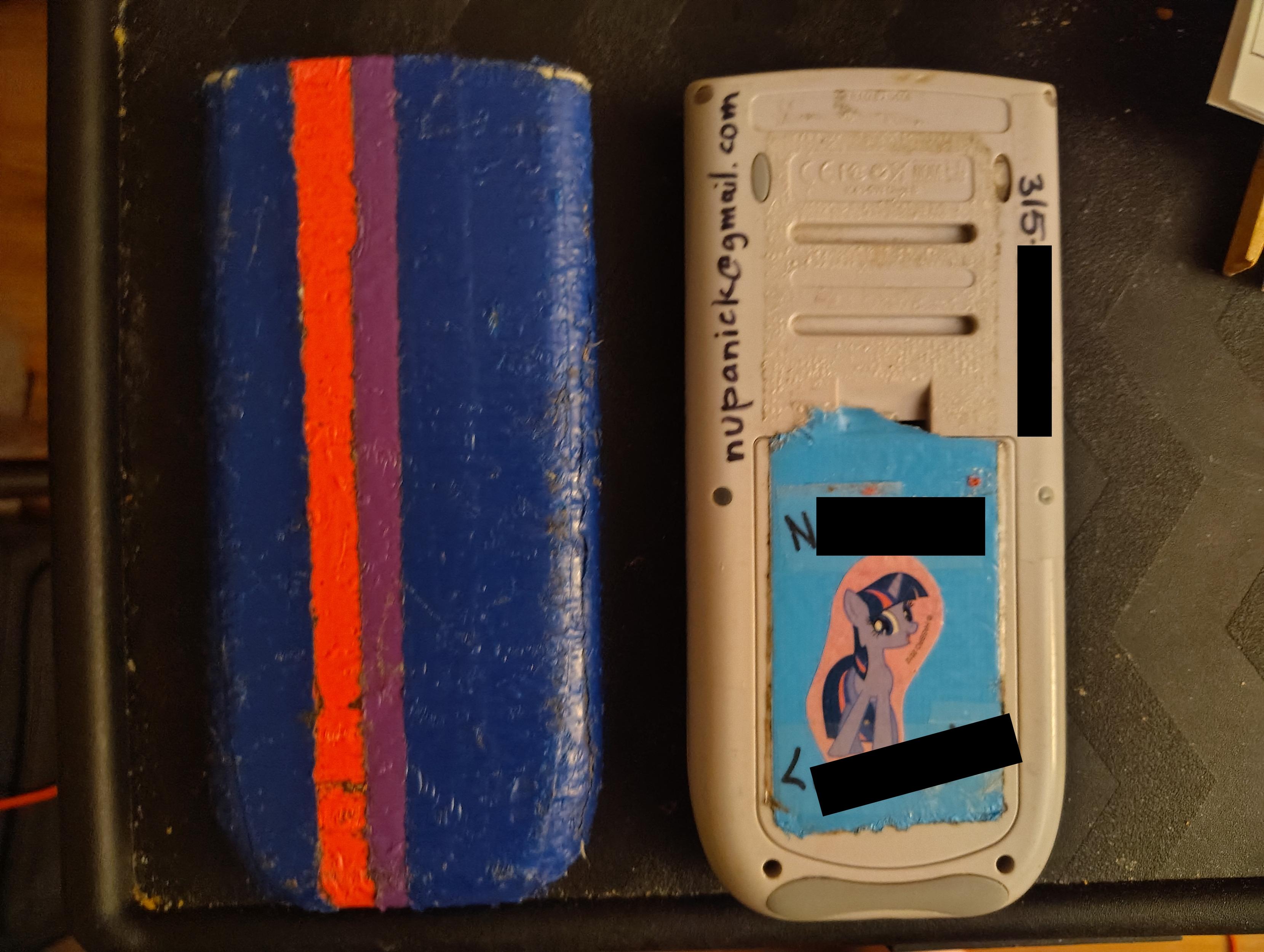 photo showing the back of the calculator. It has blue and purple duct tape stripes, and a sticker of the cartoon pony Twilight Sparkle. the stripes appear to match the pony's mane color, but only if you have protanomaly colorblindness.