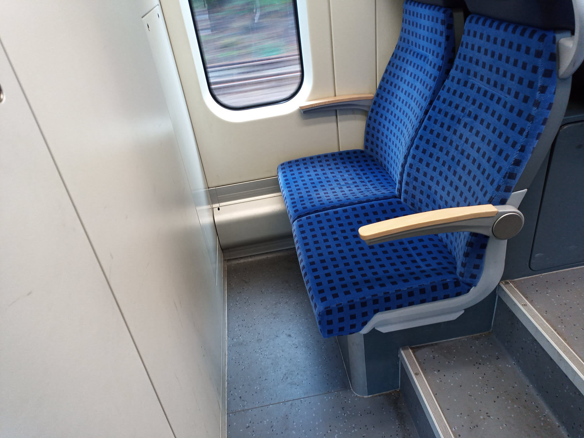 two seats in a train placed right up to a wall (about 30 centimeters of leg space maaybee?) so that your knees will definitely touch the wall. you'll also be looking at... a wall.
